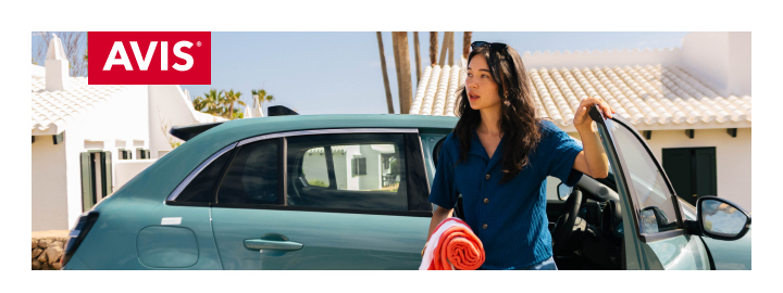 눈 내리는 겨울 숲 배경에서 크리스마스 트리가 실린 자동차 위에 두 아이가 앉아 미소 짓고 있는 모습입니다. 겨울 여행의 따뜻한 분위기와 가족 여행의 즐거움을 표현하고 있습니다. 좌측 상단에는 AVIS 로고가 표시되어 있습니다.